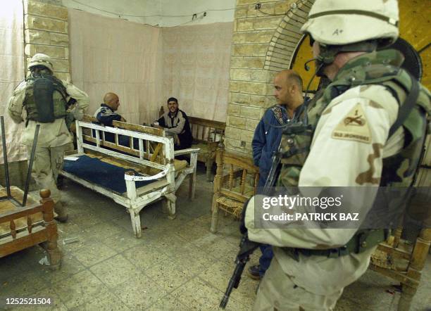 Troops from the First Armoured Division, the Second Battalion and the Third Field Artillery Regiment search a bar in Baghdad in the early hours of 20...