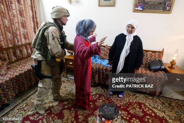 Military Police officer Nicole Bukowski frisks an Iraqi girl inside a house in the Baghdad predominant Muslim Sunni neighborhood of Azamiyah early 30...