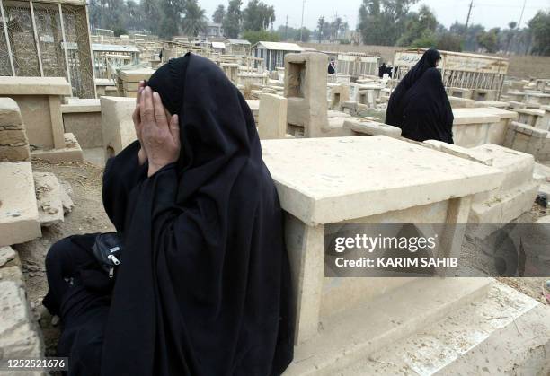 Iraqi women recite the Fatiha, the opening Surat of Koran, over the tombs of their relatives, a ritual performed by Muslims during the Eid Al-Fitr...