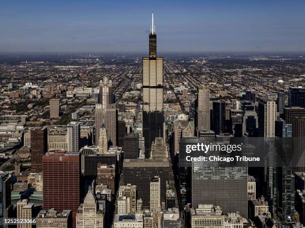 Willis Tower reflects the morning sunrise in downtown Chicago on April 26, 2023. It&apos;s been 50 years since the last beam of building, then known...