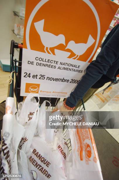 Une personne dépose un sac rempli de provisions, le 24 novembre 2006 dans une grande surface à Caen, dans le cadre de la collecte annuelle des...