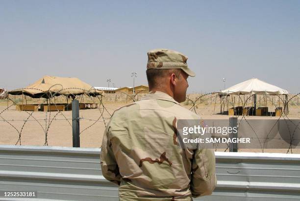 Military officer stands 16 July 2004 in front of the visitation area in the US-run Camp Bucca detention camp on the outskirts of Umm Qasr, 620 kms...