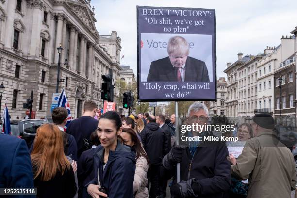 Anti-Brexit protesters continue their campaign against Brexit and the Conservative government in Westminster with a placard depicting a downcast...