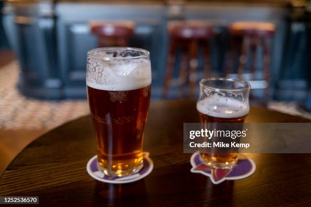 Pint and a half of English ale on a pub table on 12th April 2023 in Birmingham, United Kingdom. Beer prices in the UK have been on the rise with...