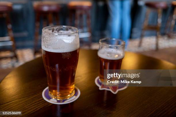 Pint and a half of English ale on a pub table on 12th April 2023 in Birmingham, United Kingdom. Beer prices in the UK have been on the rise with...