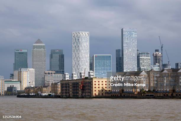 Residential homes and wharf buildings along the River Thames with One Canada Square and many other more recently built skyscrapers at the heart of...
