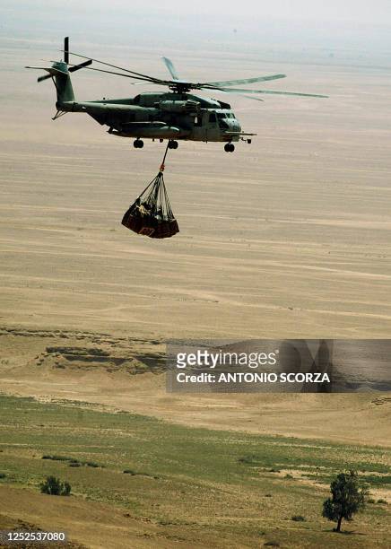 Marine C853 helicopter flies over the desert 26 May 2004, transporting supplies between al-Asad air base and the al-Qaim marine base in the west of...