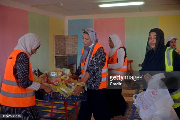 Volunteers prepare aid packages for refugees fleeing war-torn Sudan, at the Wadi Karkar bus station near the Egyptian city of Aswan, on May 2, 2023....