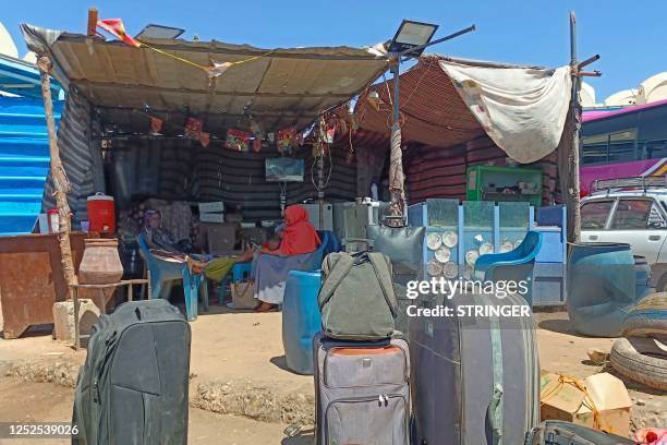 Refugees who fled war-torn Sudan, wait in the shade at the Wadi Karkar bus station near the Egyptian city of Aswan on May 2, 2023. - Warring generals...