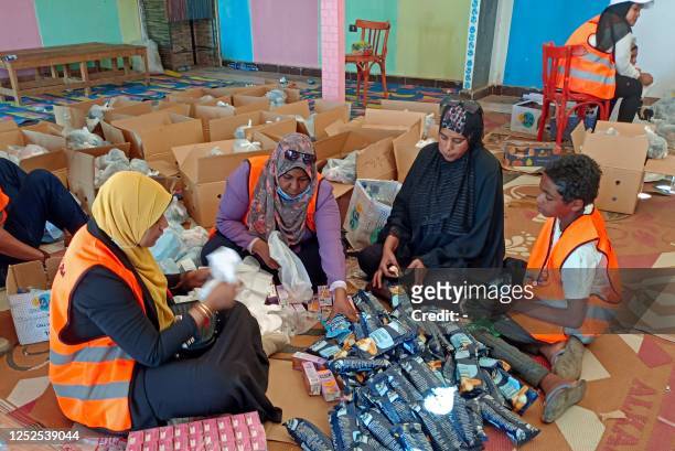 Volunteers prepare aid packages for refugees fleeing war-torn Sudan, at the Wadi Karkar bus station near the Egyptian city of Aswan, on May 2, 2023....