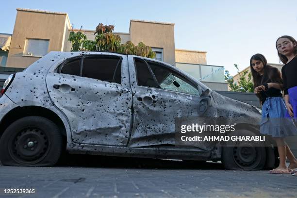 Children look at a damaged car in the southern Israeli city of Sderot on May 2 following a flare-up between the Israeli military and Gaza militants....
