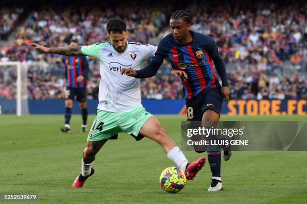 Osasuna's Spanish midfielder Ruben Garcia Santos tackles Barcelona's Spanish defender Alejandro Balde during the Spanish league football match...