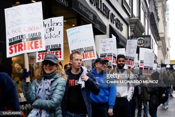 Demonstrators carry signs during a screenwriter's strike in New York City on May 2, 2023. - More than 11,000 Hollywood television and movie writers...