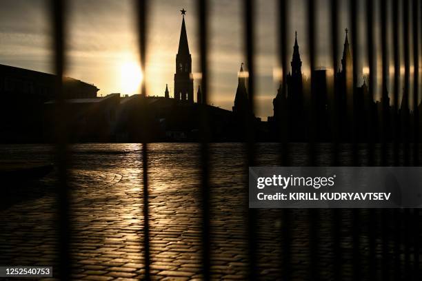 This photograph taken on May 2 shows one of the Kremlin tower through a fence on the empty Red Square in central Moscow. - The main square of the...