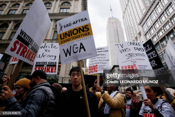 Demonstrators carry signs during a screenwriter's strike in New York City on May 2, 2023. - More than 11,000 Hollywood television and movie writers...