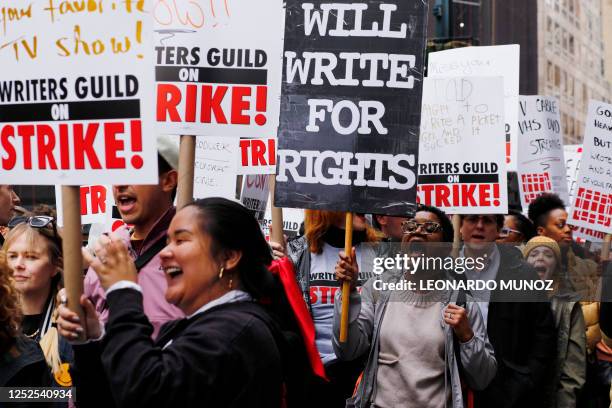 Demonstrators carry signs during a screenwriter's strike in New York City on May 2, 2023. - More than 11,000 Hollywood television and movie writers...