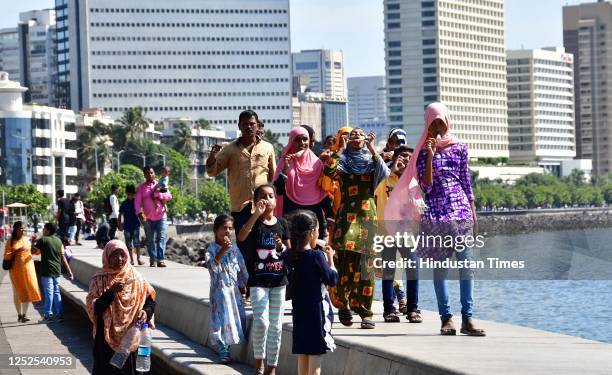 People cover themselves in the sweltering heat, at Marine Drive, on May 2, 2023 in Mumbai, India.