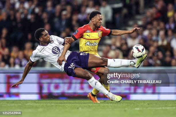 Toulouse's Cape Verdean defender Logan Costa fights for the ball with Lens' Belgian forward Lois Openda during the French L1 football match between...