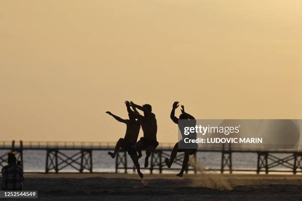 People jump on the beach in Saint-Jean-de-Monts on May 2, 2023.