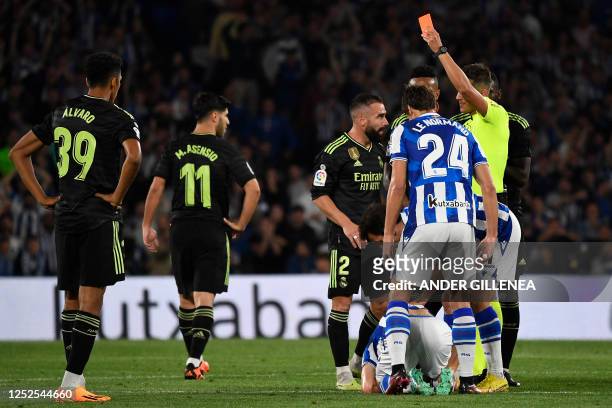 Spanish referee Pulido Santana presents a red card to Real Madrid's Spanish defender Dani Carvajal during the Spanish league football match between...