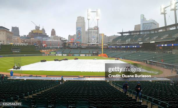 Fans walk around Comerica Park while waiting out a rain delay as the tarp covers the field ahead of a game between the Detroit Tigers and New York...