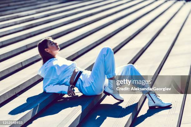 female showing off her white tracksuit outside - all hip hop models stock pictures, royalty-free photos & images