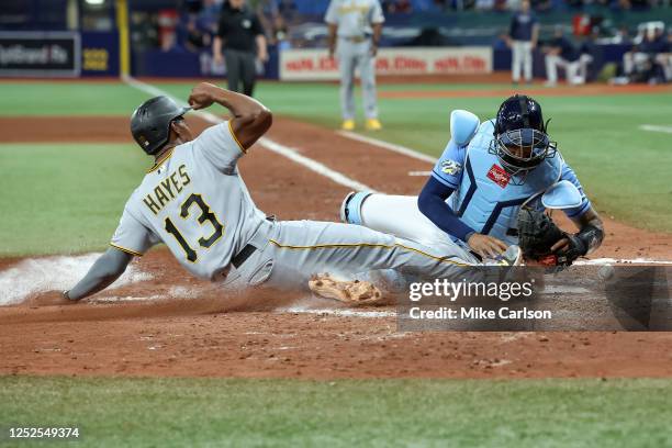 Ke'Bryan Hayes of the Pittsburgh Pirates scores as Christian Bethancourt of the Tampa Bay Rays cannot keep the ball during the fifth inning at...