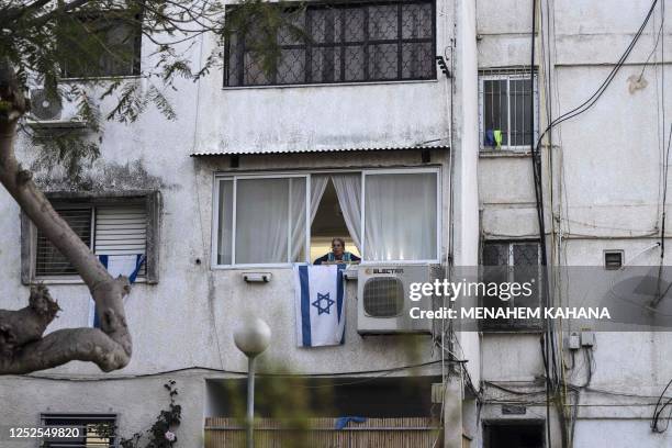 In this picture taken on April 27 a woman stands a her apartment window in the southern Israeli city of Ashkelon. - Now 75 years old, Israel models...