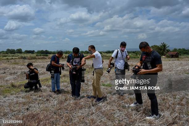 Photojournalists work at a dried-up rice field, on the World Press Freedom Day, in Naic in the Philippine Province of Cavite on May 3, 2023.