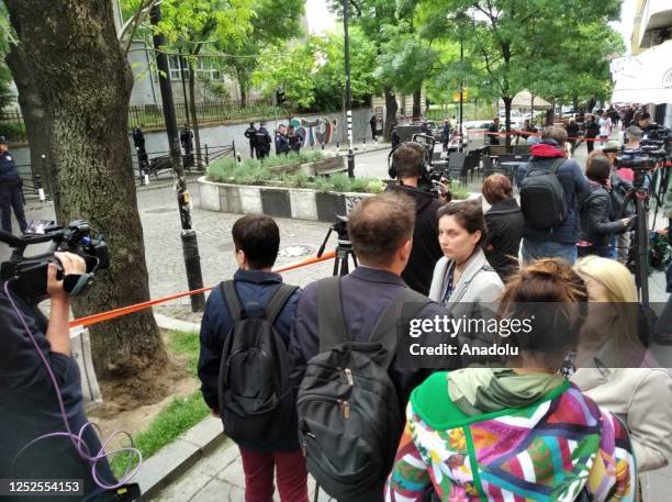 People wait outside the elementary school while police take security measures after a 7th grade student opened fire at the school, in Belgrade,...