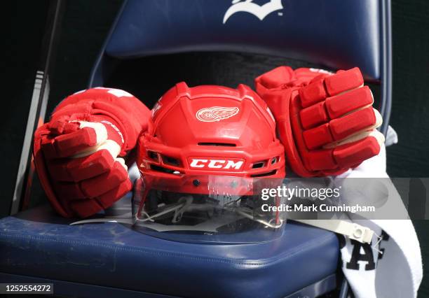 Detailed view of a Detroit Red Wings hockey helmet and gloves sitting in the Detroit Tigers dugout during game one of a doubleheader against the...