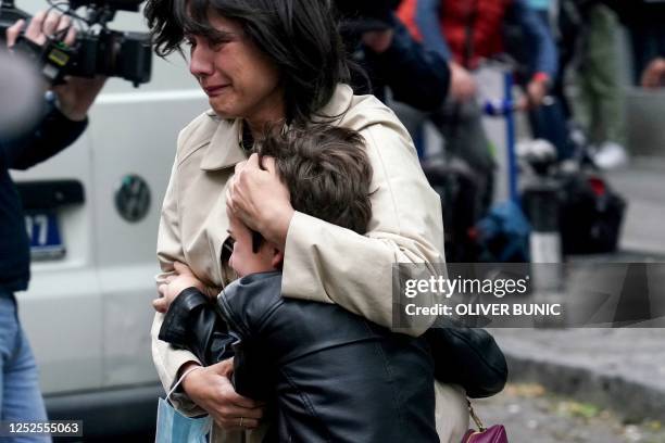 Parent escorts her child following a shooting at a school in the capital Belgrade on May 3, 2023. - Serbian police arrested a student following a...