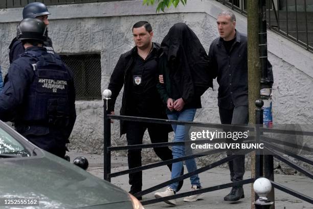 Police officers escort a minor, a seventh grade student who is suspected of firing several shots at a school in the capital Belgrade on May 3, 2023....