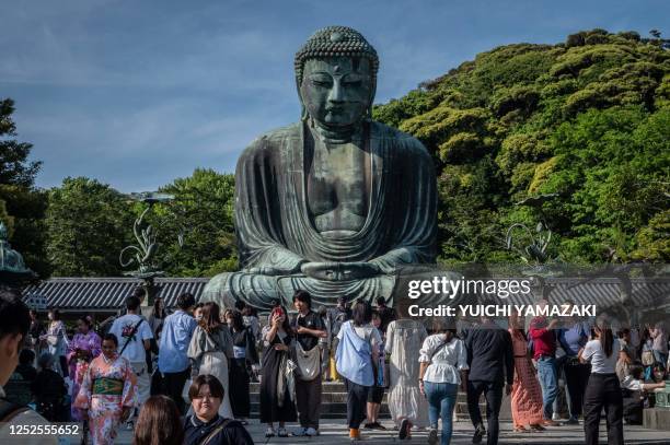 People visit the Great Buddha statue at Kotoku-in temple in Kamakura city of Kanagawa prefecture on May 3, 2023.