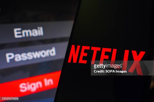 In this photo illustration, the Netflix logo is displayed on a smartphone screen, next to a login screen, with email, password, and sign in.