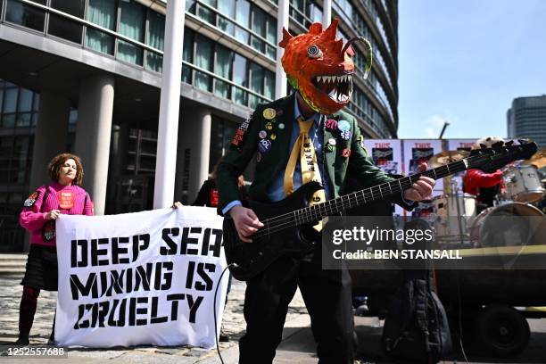 Activists in the 'heavy metals band' Polymetallic Nodules, part of the Ocean Rebellion protest group, demonstrate outside the Marriott Hotel in the...