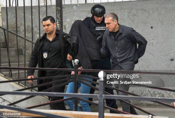 Police officers escort a minor, a seventh grade student who is suspected of firing several shots at a school in the capital Belgrade on May 3, 2023...