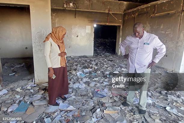 People inspect a destroyed medical storage in Nyala, the capital of South Darfur province, on May 2, 2023 as deadly clashes between rival generals'...