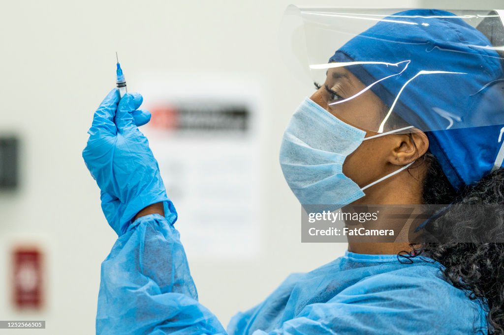Female Medical Professional inspecting a syringe