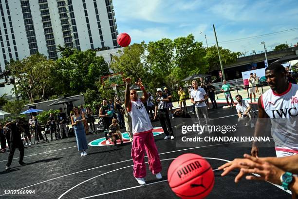 Mercedes' British driver Lewis Hamilton plays with a basketball during a IWC Schaffhausen basketball event ahead of the Miami Grand Prix in Miami,...