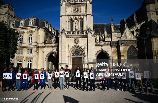 Activits from by the "Attac" association hold placards reading "we don't turn the page" during a demonstration at Place du Louvre following a...