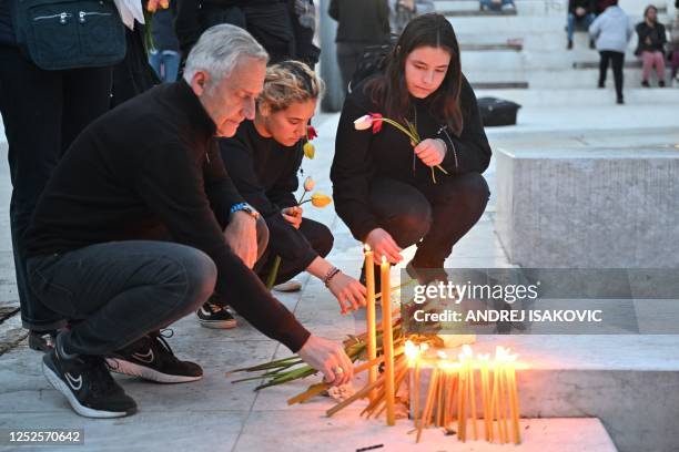 People light candles following a shooting at a school in the capital Belgrade on May 3, 2023. - Serbian police arrested a student following a...