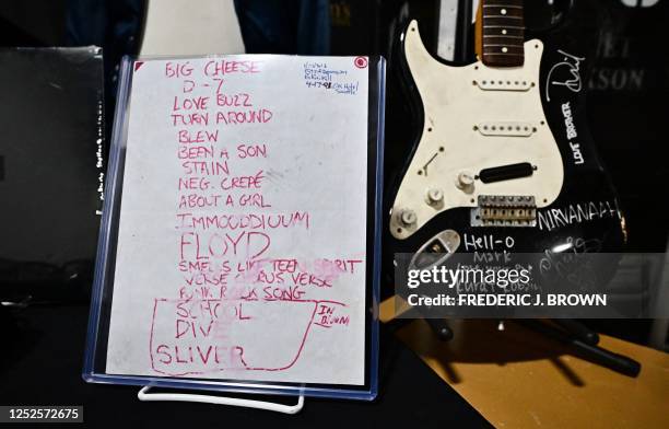Musician Kurt Cobain's smashed Fender Stratocaster is displayed beside the 1991 "Smells Like Teen Spirit" debut performance set list at Julien's...