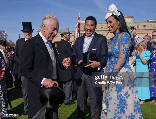 King Charles III speaks to Lionel Richie and Lisa Parigi during the Garden Party at Buckingham Palace ahead of the coronation of the King Charles III...