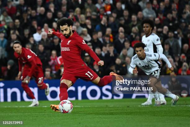 Liverpool's Egyptian striker Mohamed Salah shoots a penalty kick and scores his team first goal during the English Premier League football match...
