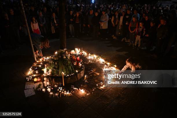 People light candles during a vigil following a shooting at a school in the Serbian capital Belgrade on May 3, 2023. - Serbian police arrested a...