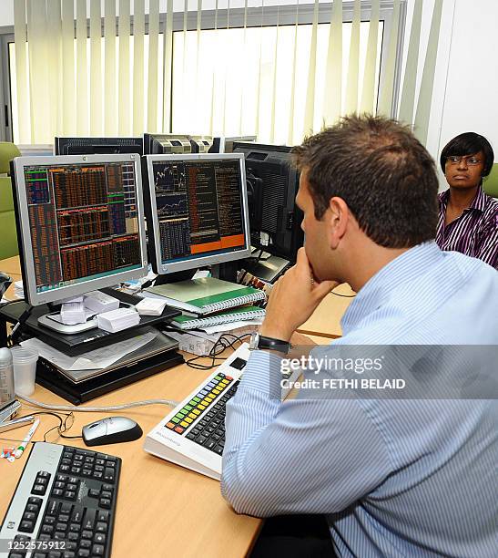 Traders of the African Development Bank follow the market's movement at the Stock Exchange on her computer on June 1, 2011. The ADB president, Donald...