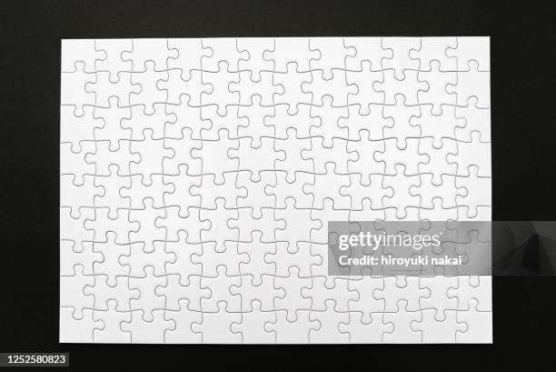 a white jigsaw puzzle - puzzle fotografías e imágenes de stock