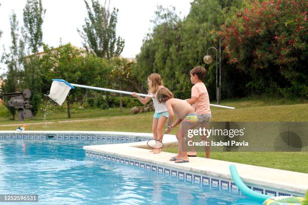 children cleaning out swimming pool - swimming pool cleaning stock pictures, royalty-free photos & images