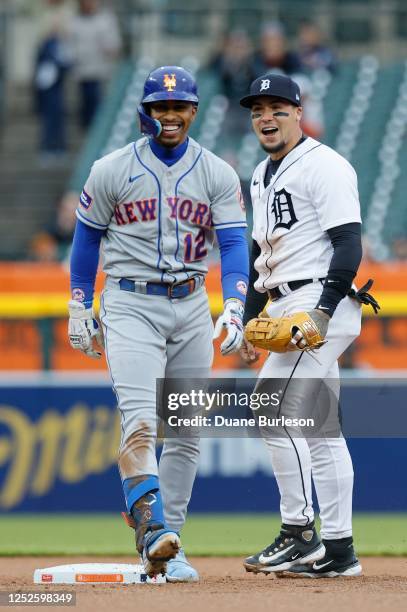 Francisco Lindor of the New York Mets laughs after he was tagged out by shortstop Javier Baez of the Detroit Tigers while trying to stretch a hit...